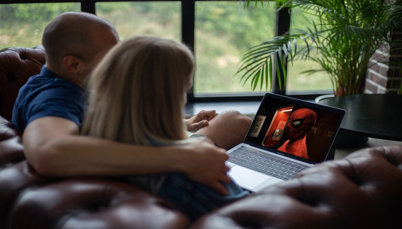 Pareja viendo una película en una computadora portátil a través de streaming..