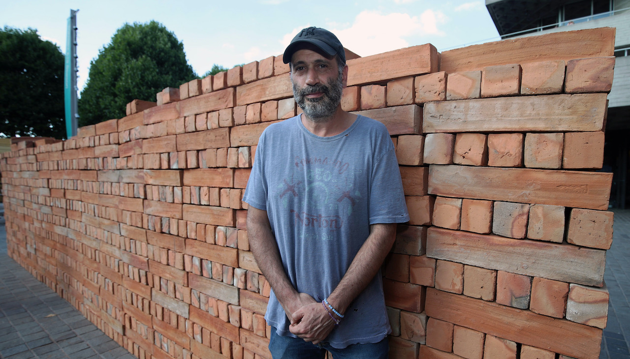 Mexican artist Bosco Sodi poses next to his artwork Muro, a wall built on London's South Bank to protest against US President Donald Trump. Photo: Yui Mok/PA Images via Getty Images.