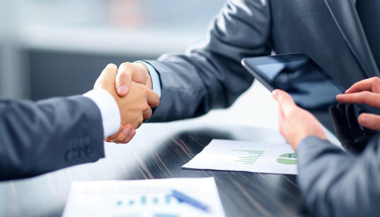 Bank employee shakes hand with costumer.