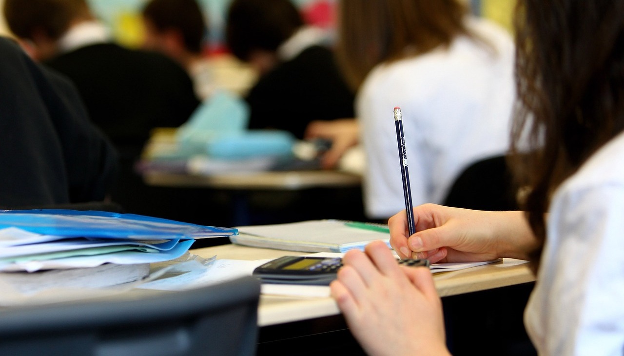 A girl takes notes during a college class. 