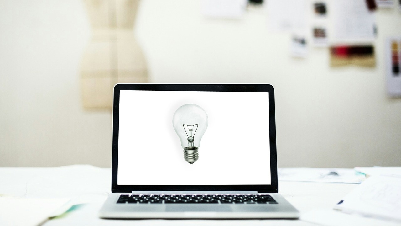 A bulb is displayed on a laptop to illustrate creativity.