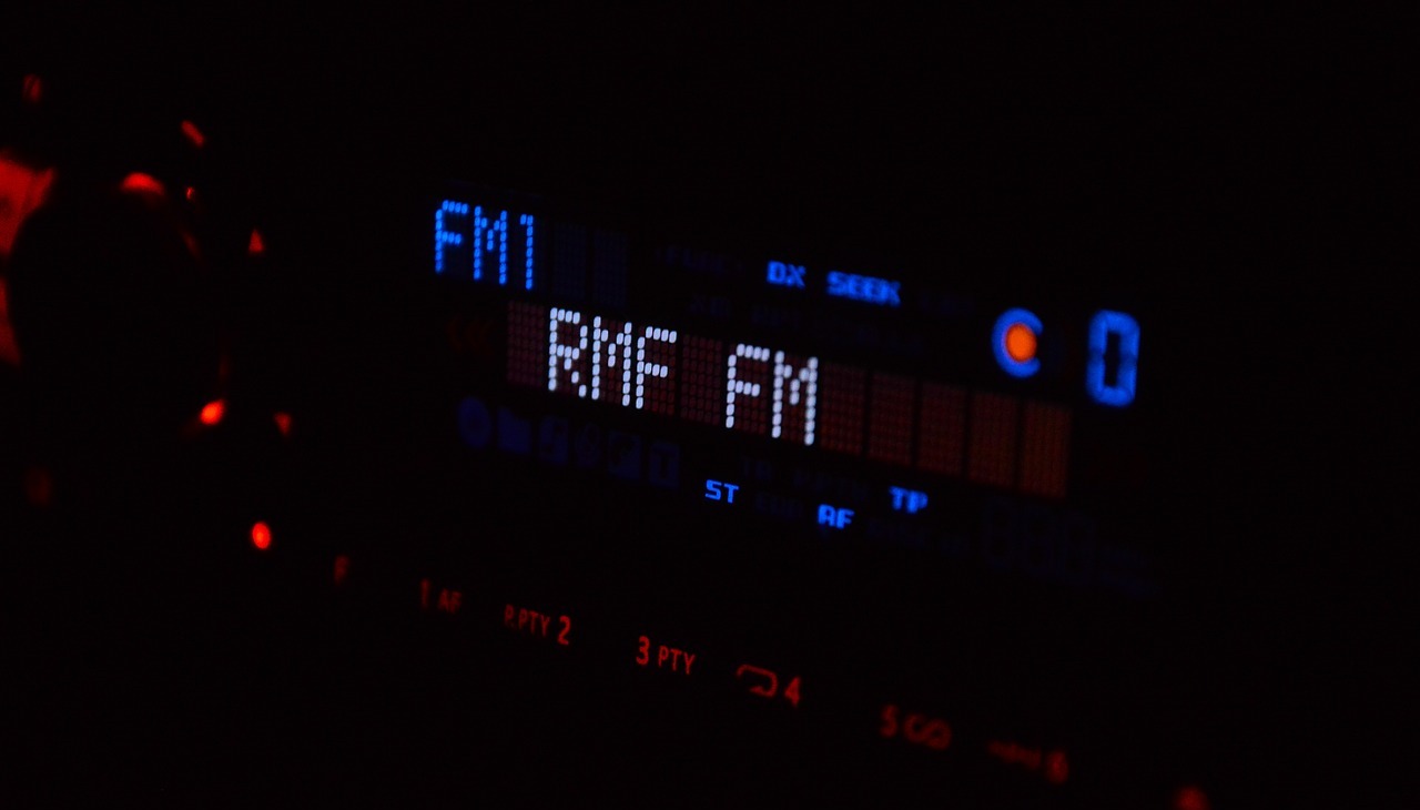 Car radio screen displaying fm radio station. 