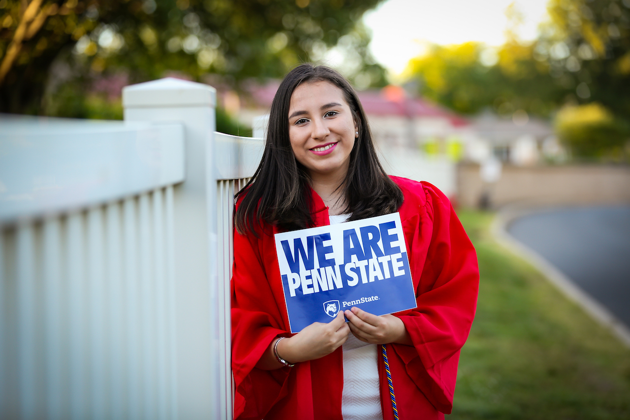 Samantha Escobar holding a Penn State poster. 