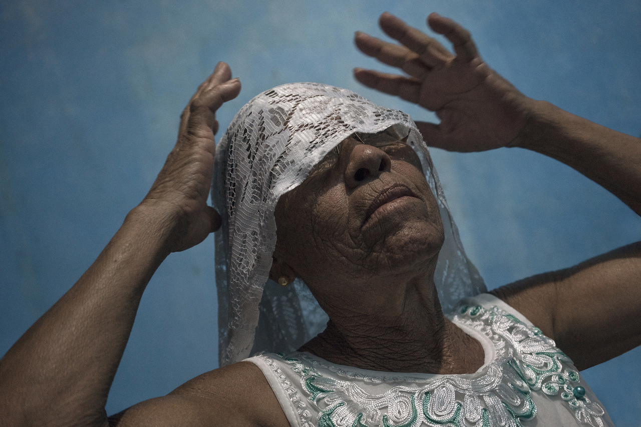 A woman performs a religious celebration called Umbanda. It is a syncretic Afro Brazilian religion that blends African traditions with Catholicism, Spiritism, and Indigenous American beliefs. February 19th, 2017. Andaraí, Brazil. © Tamara Merino