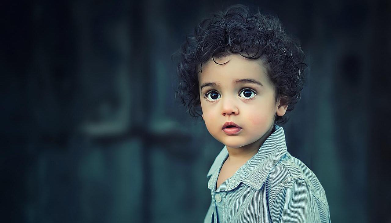 Child looking the horizon in front of his house. 