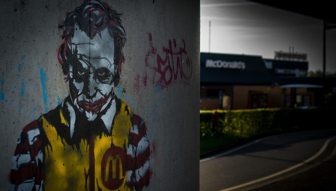 Graffiti with Batman's Joker next to a McDonald's location.