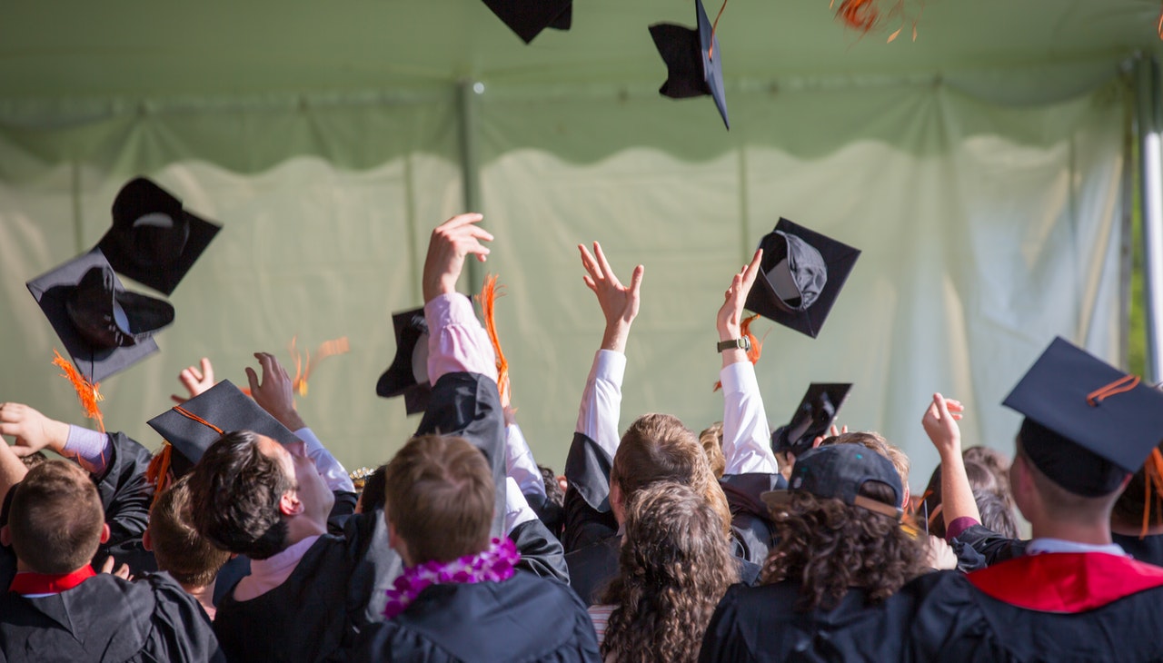 Graduate students throwing their caps. 