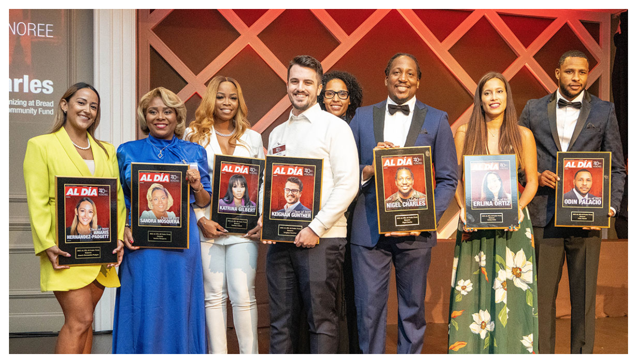 A group of ten 40 Under Forty honorees holding their awards on stage.