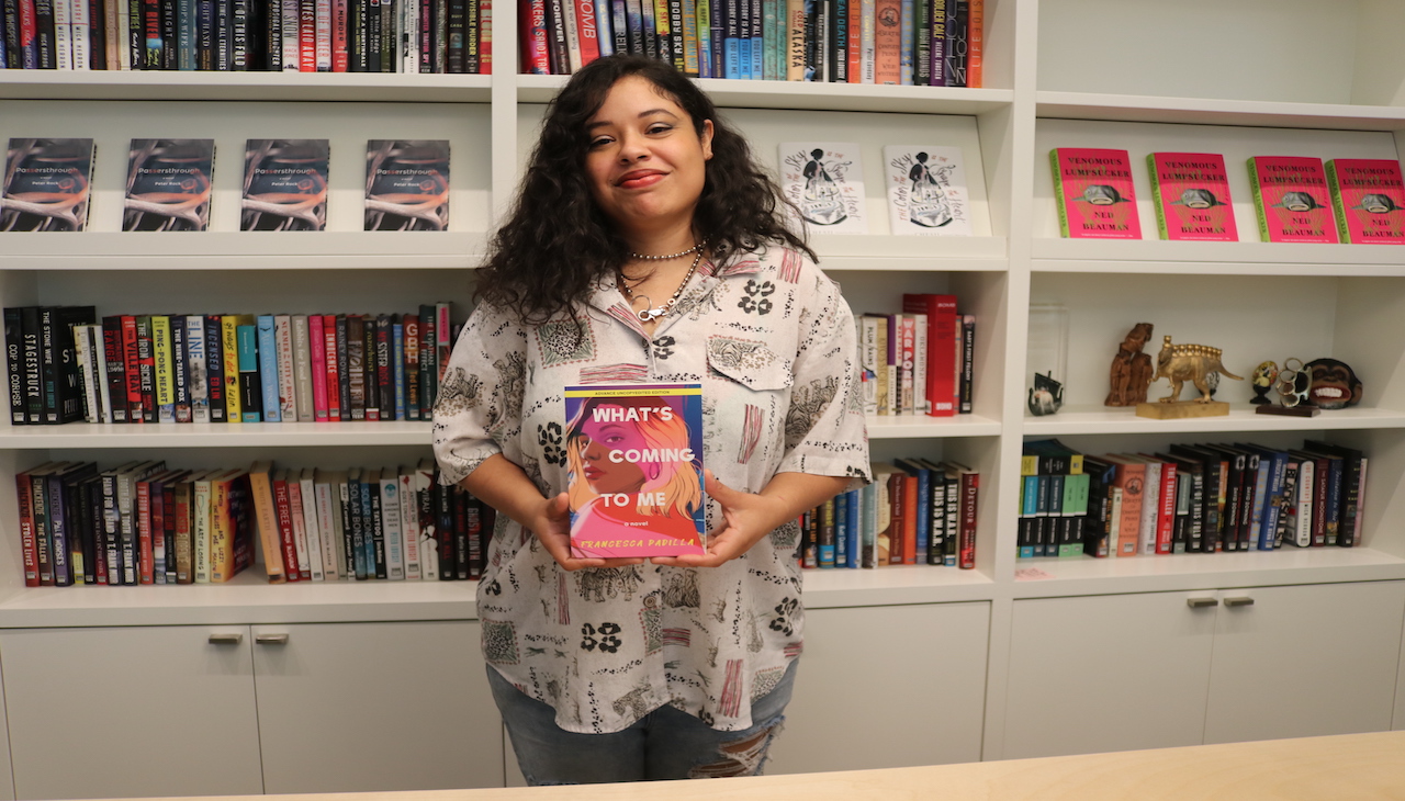 Francesca Padilla holding a copy of What's Coming to Me. 