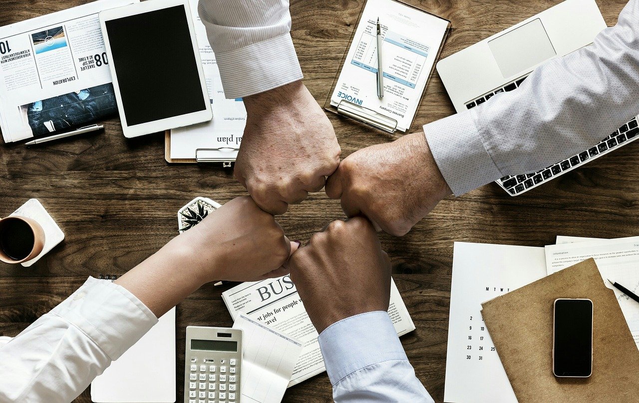 A group of coworkers making the fist gesture. 