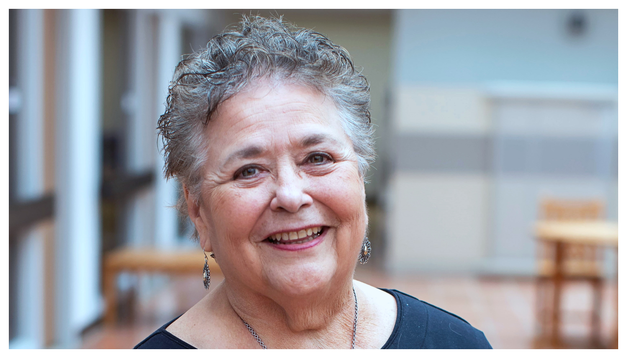 Norma Martinez Rogers: an elderly Latina woman with graying hair. She is smiling at the camera.