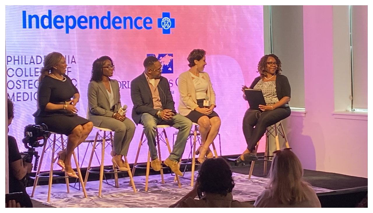 The panelists and the moderator onstage, each sitting on stools.