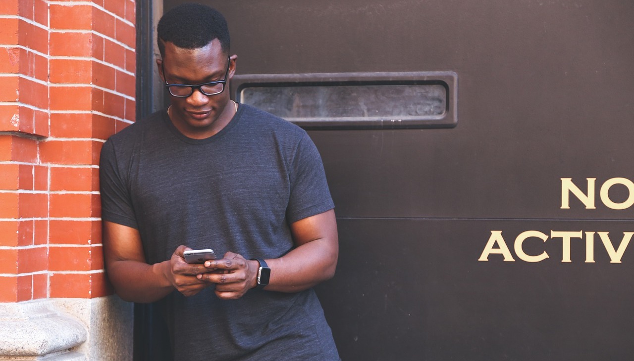 African-American man looking at his phone.