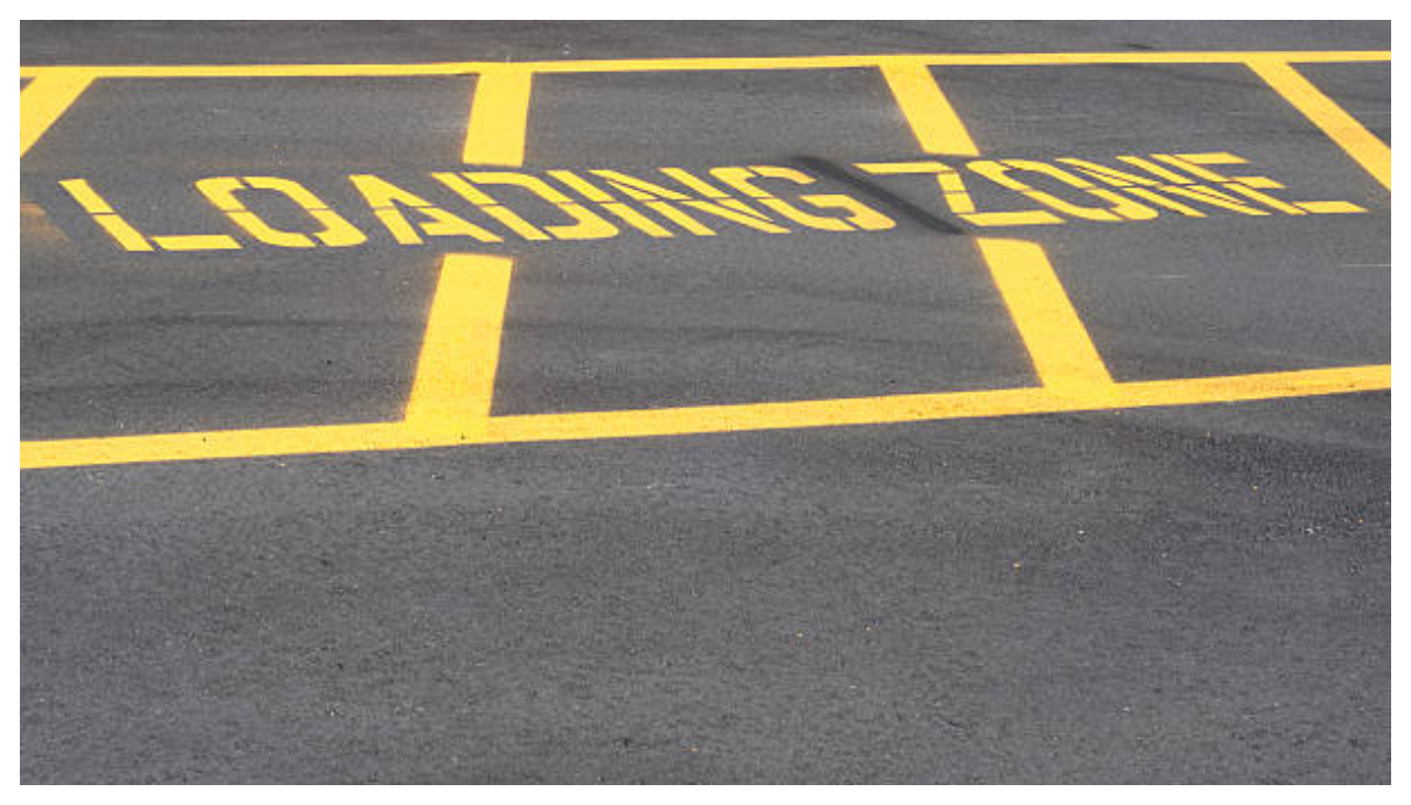 A loading zone marked with yellow lines and text in caps reading "LOADING ZONE".