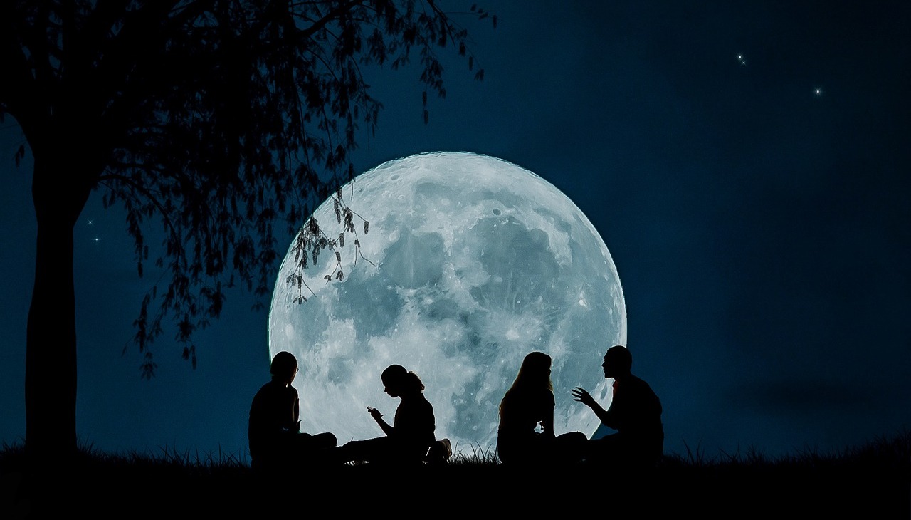 People sitting under the moon light. 