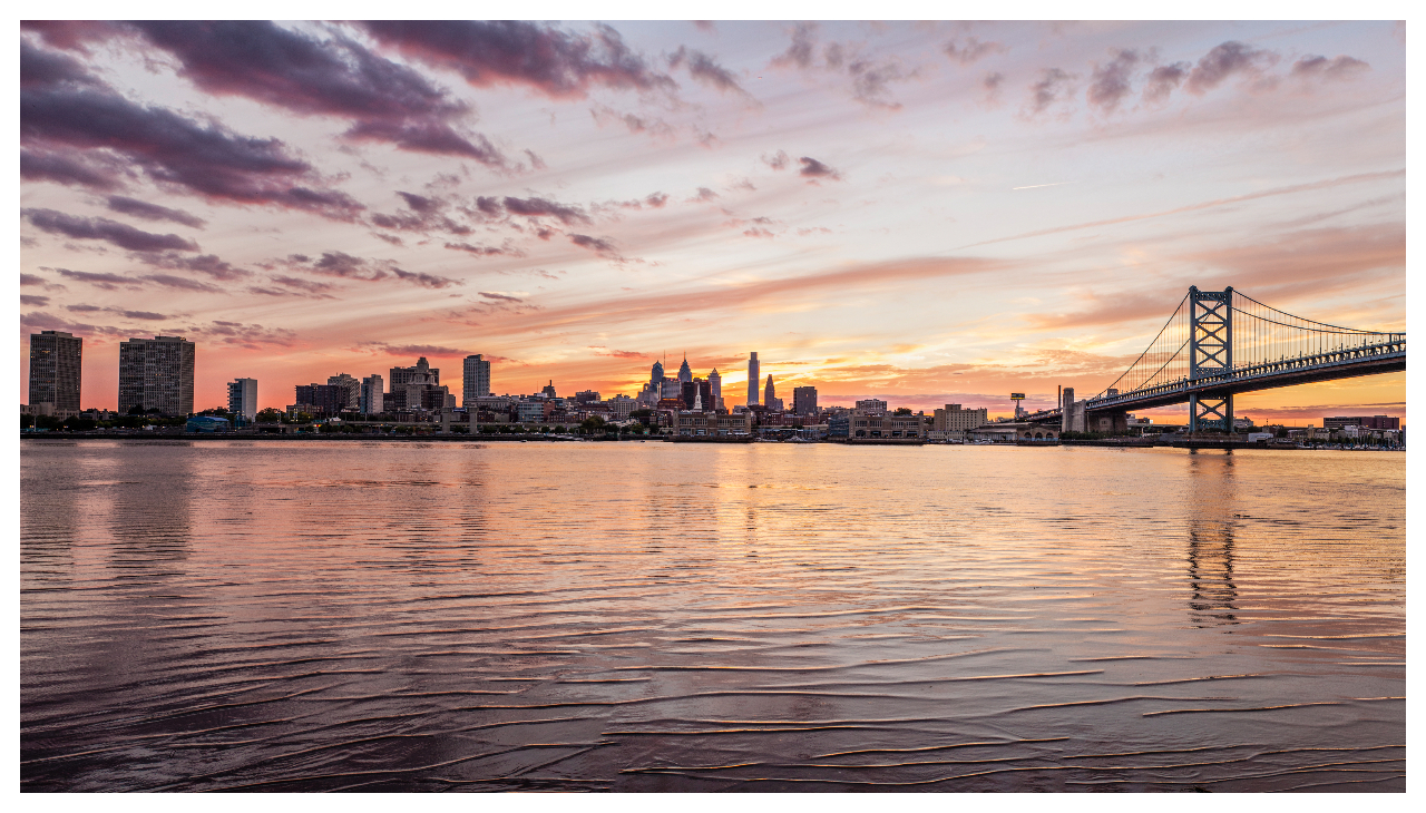 Sunset over Delaware River and the Philadelphia skyline with Ben Franklin Bridge seen from Camden, New Jersey.