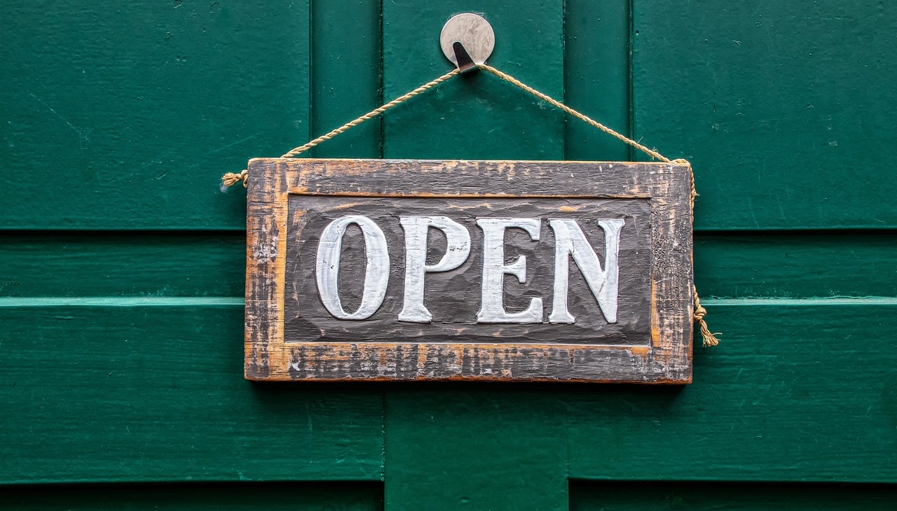 Open sign on a wooden door. 