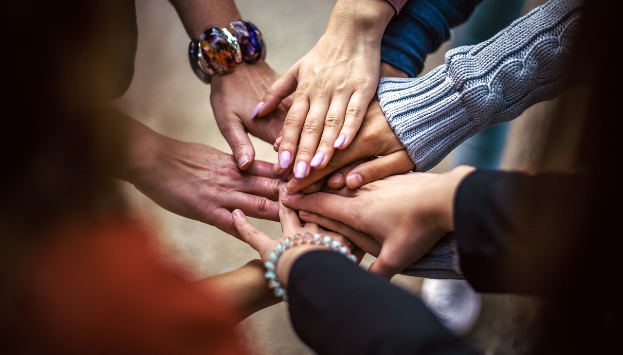 A group of people joining hands. 