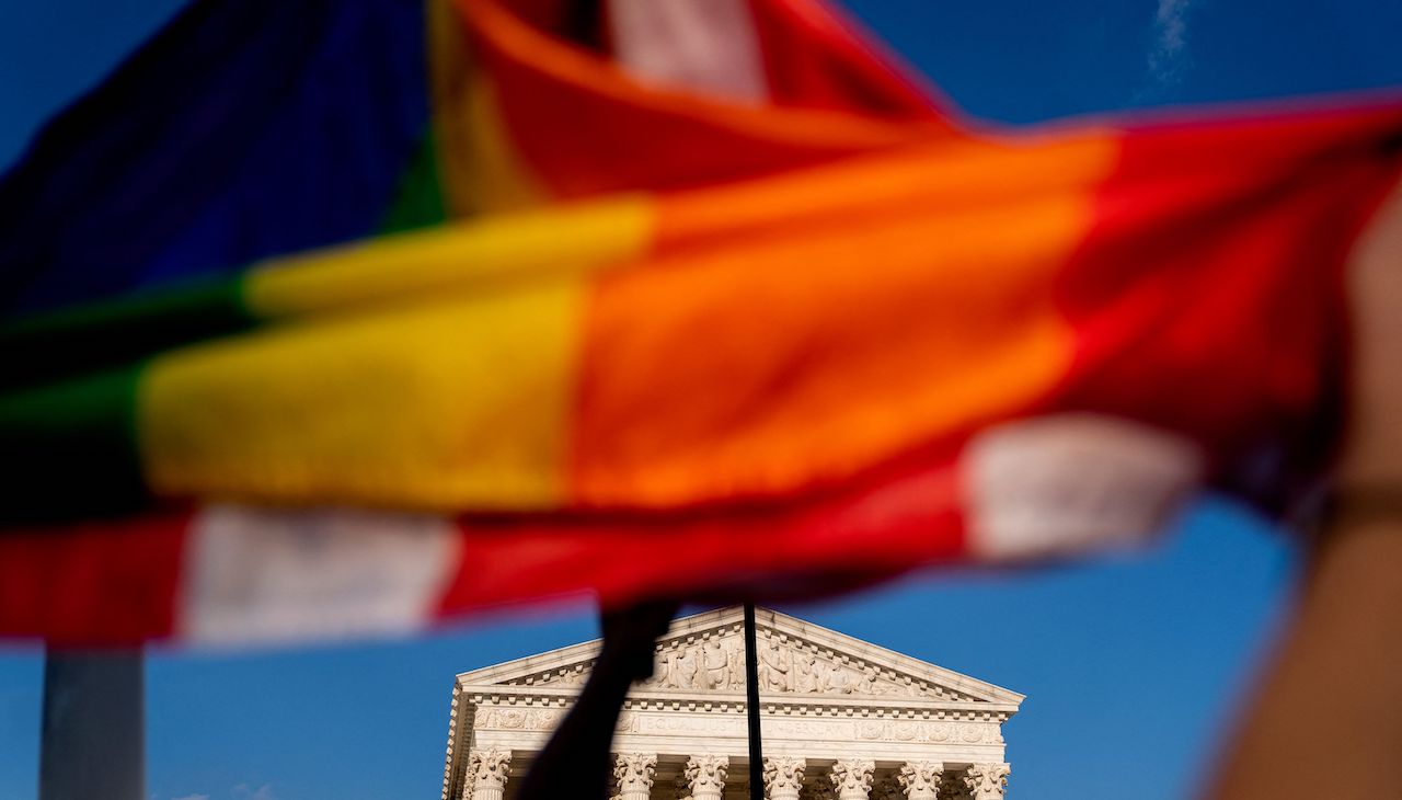 Marriage flag and US flag hang over each other and are flown over the US Supreme Court building. Photo by STEFANI REYNOLDS/AFP via Getty Images