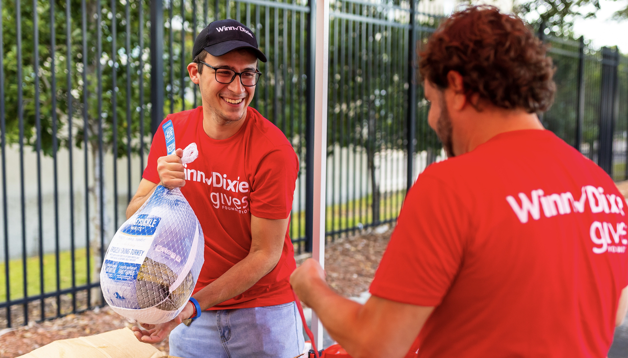 Southeastern Grocers employees sharing turkeys. 