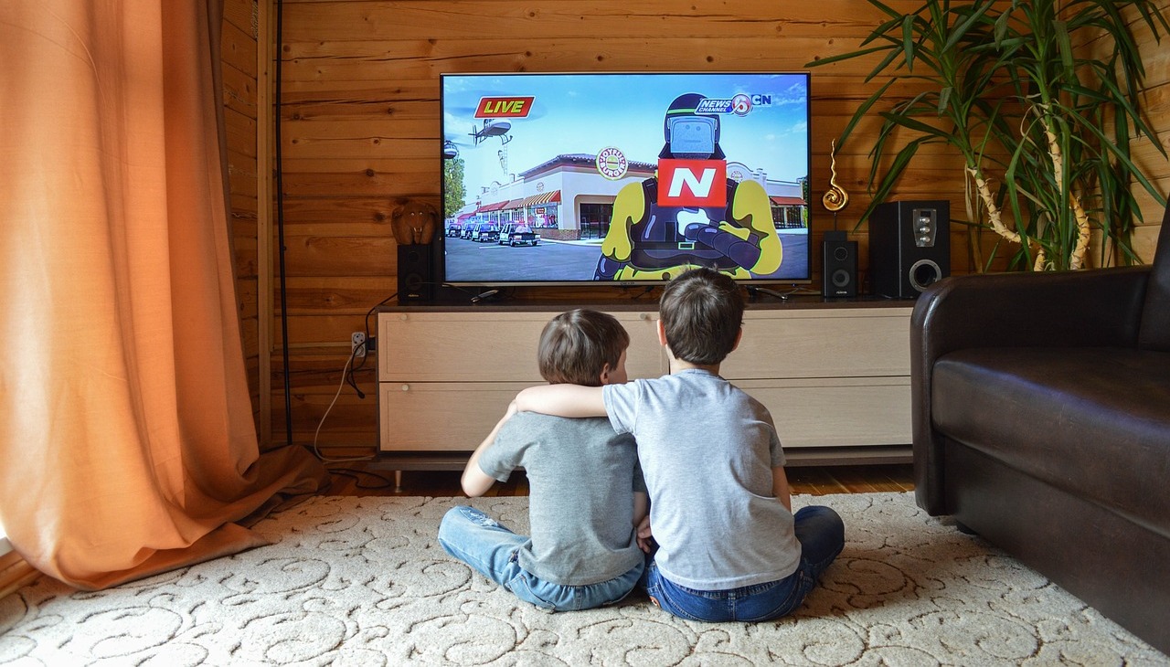 Kids watching tv in the living room. 