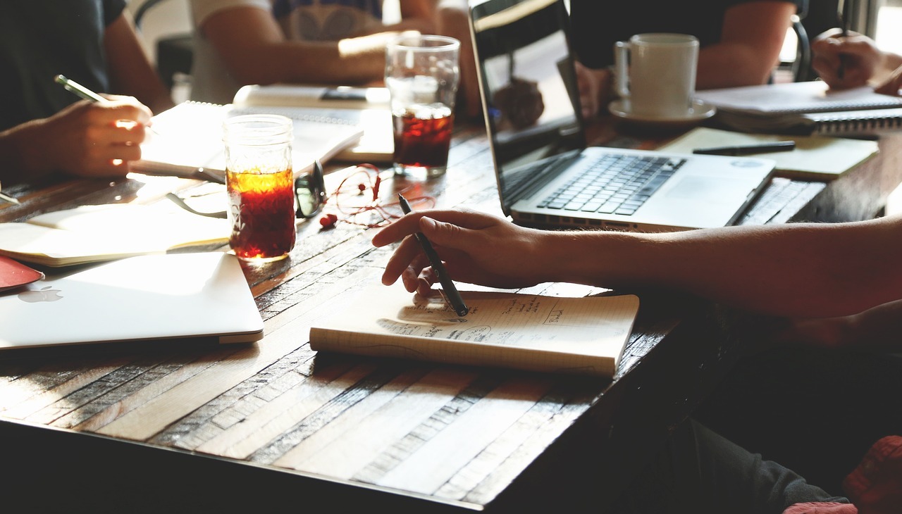 People working in a table with beverages. 