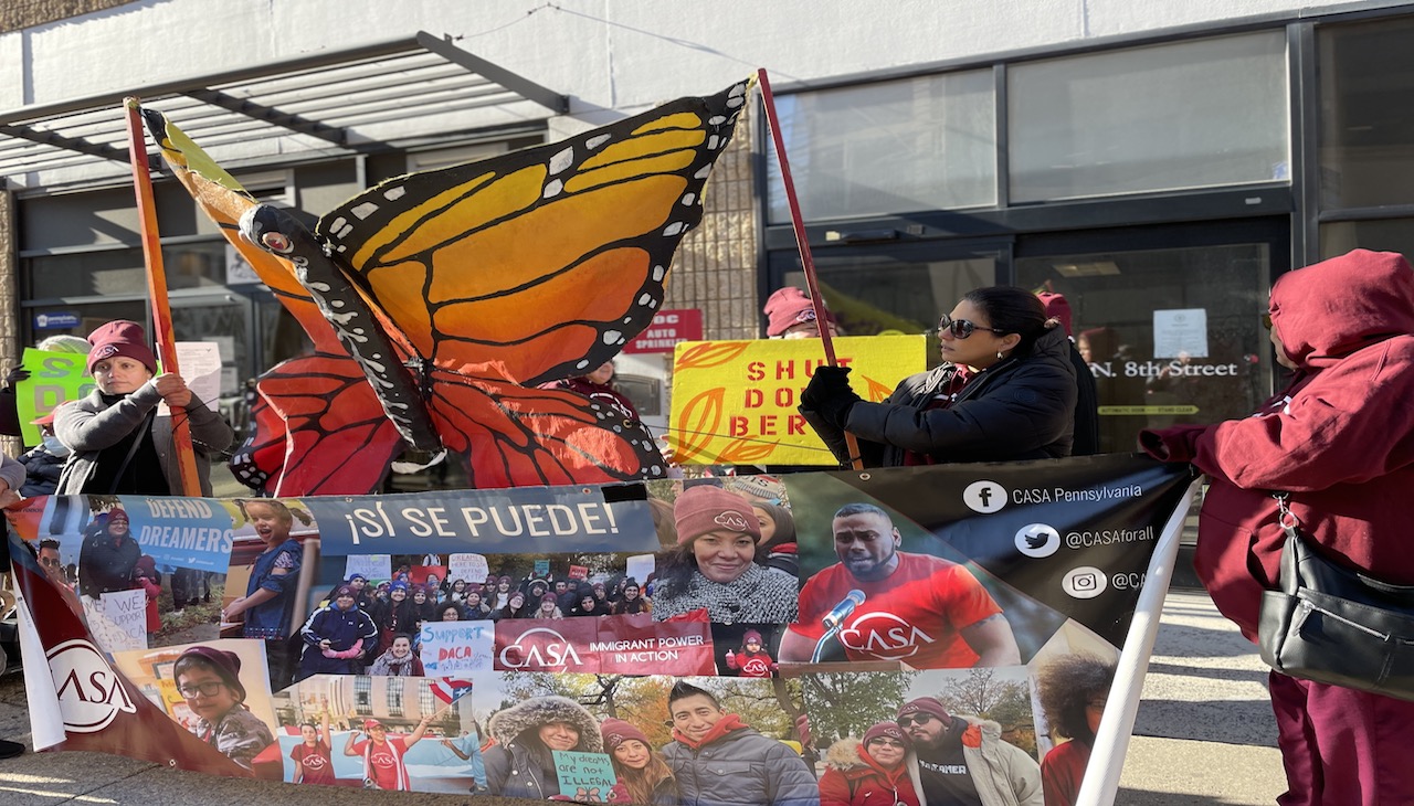 Immigration activists hold banner with a collage from other coalitions.