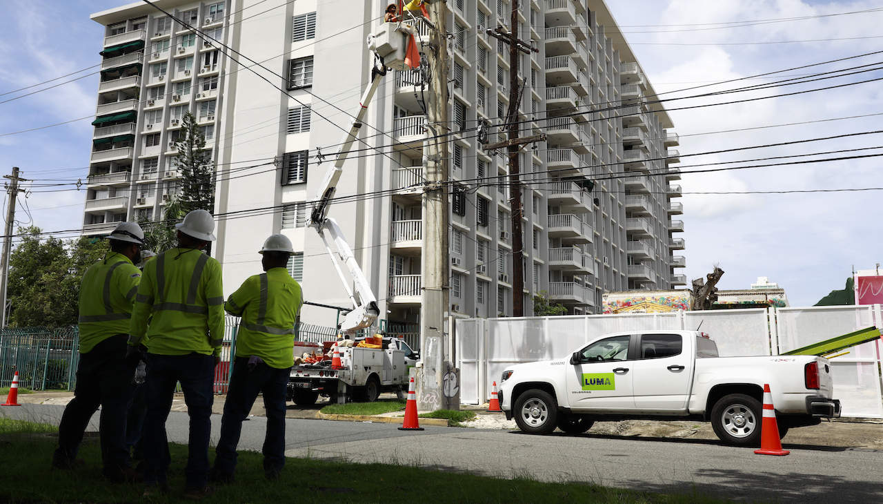 LUMA linemen work on a building. 