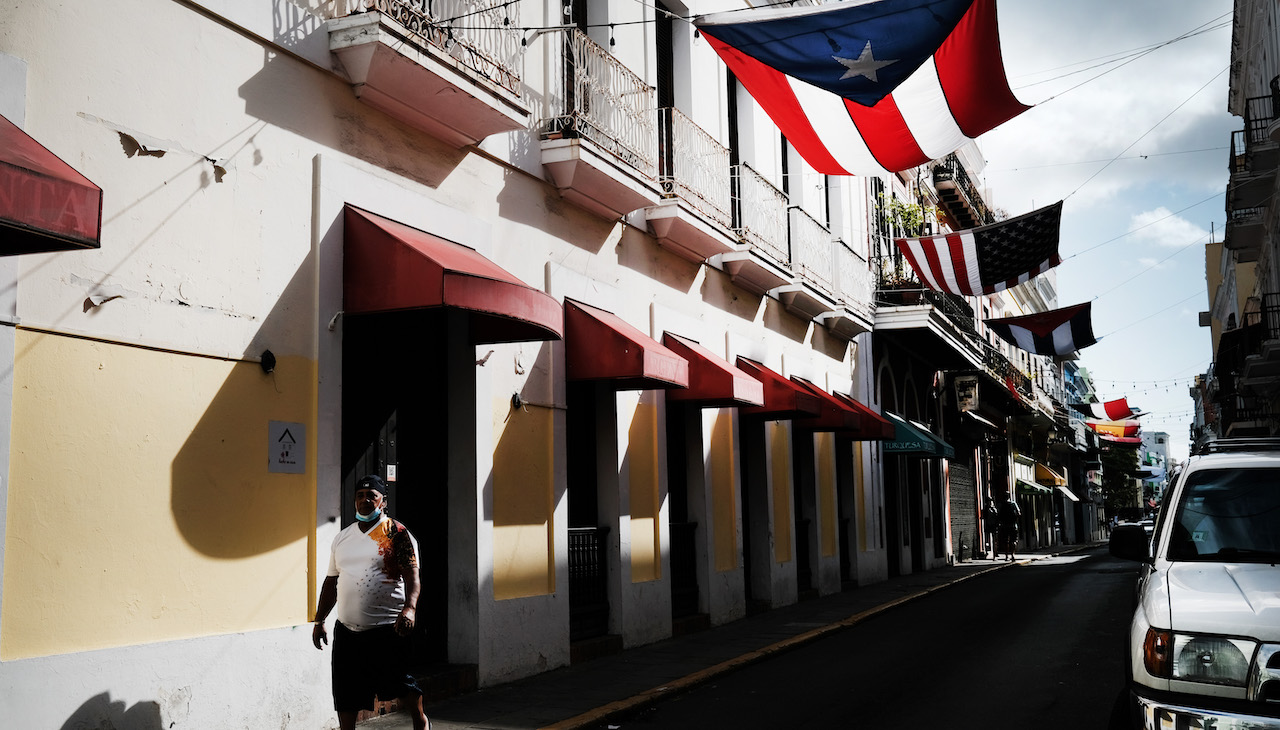 A picture of Old San Juan with Latin American flags hanging on the street.