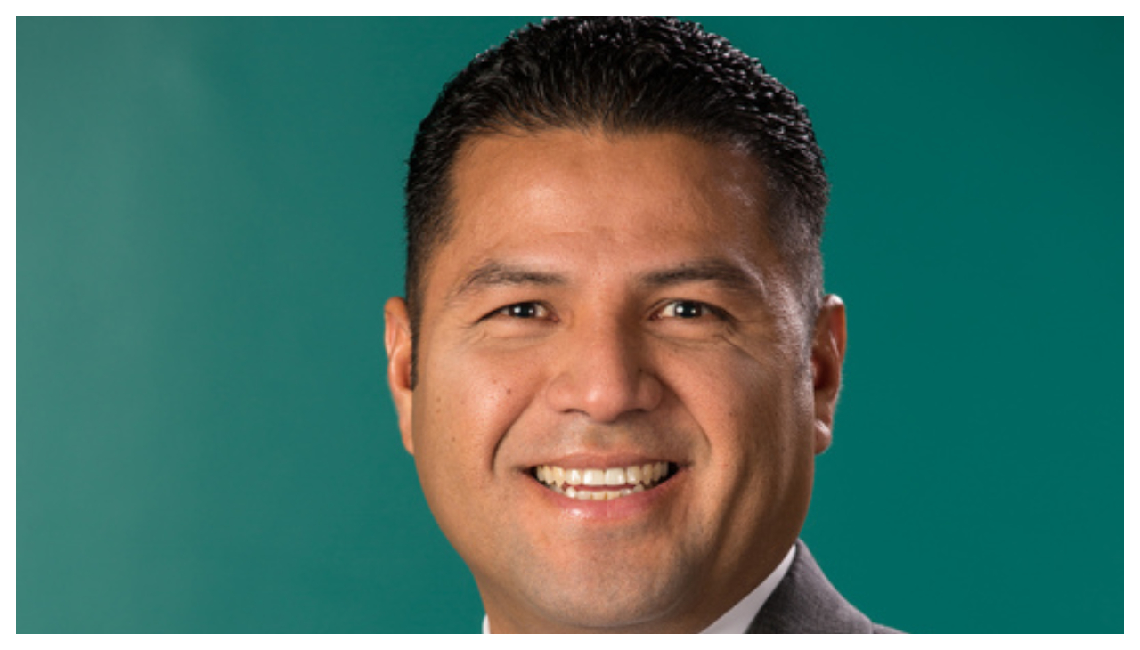 A headshot of Louis Lopez, a Hispanic man with short hair and light brown skin. He has short hair, and is facing the viewer. He is smiling.