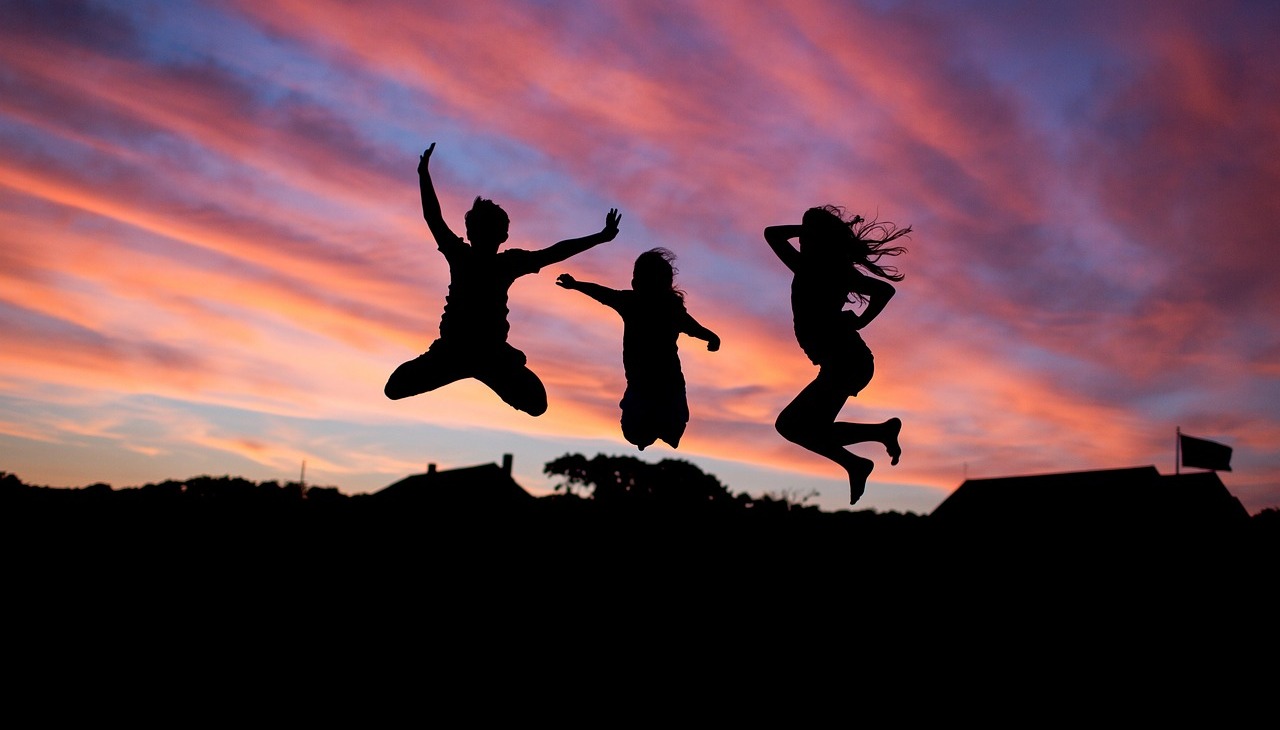 People jumping while watching a sunset. 