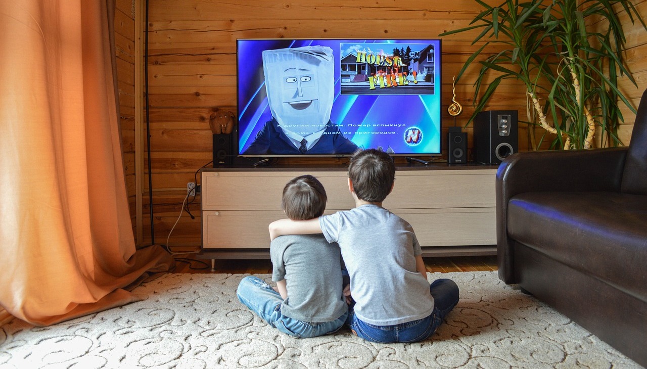 Kids watching tv in the living room. 