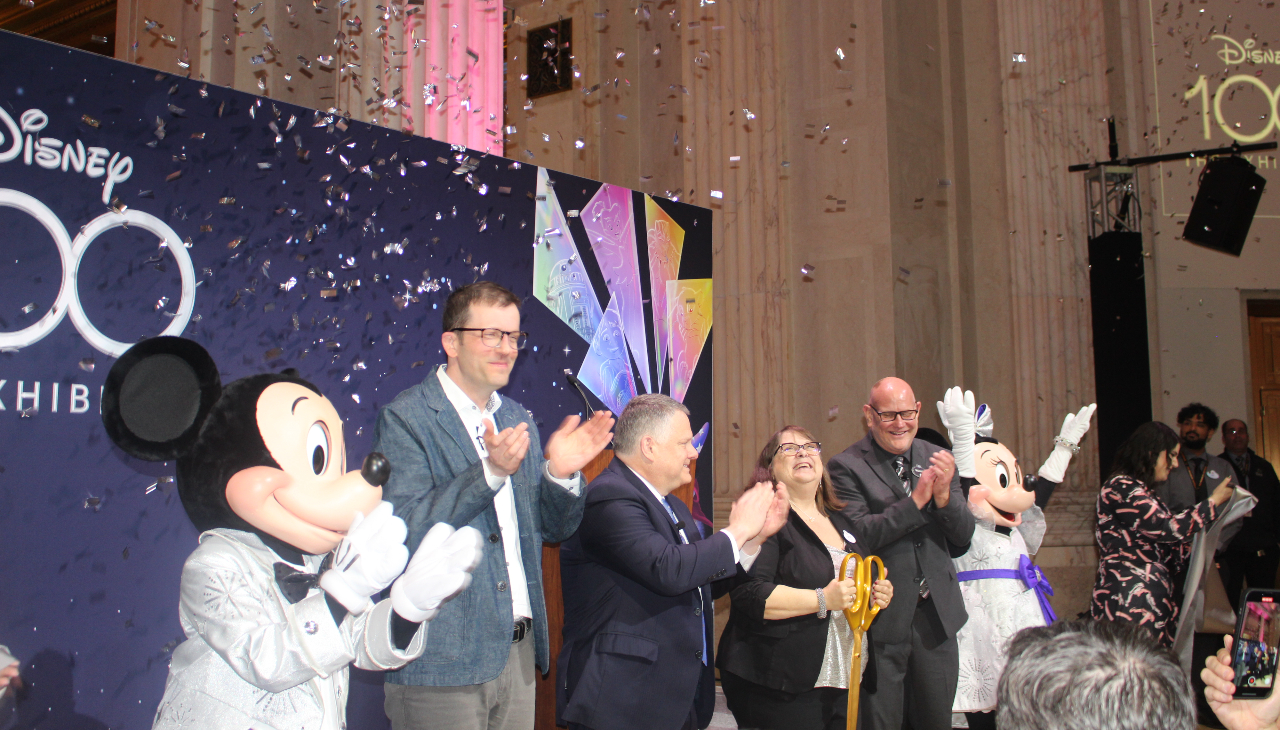 (From left to right) Mickey Mouse, Christoph Scholz, Larry Dubinski, Rebecca Cline, Michael Vargo and Minnie Mouse celebrate after ribbon cutting. Photo credit: Emily Leopard-Davis/AL DÍA News