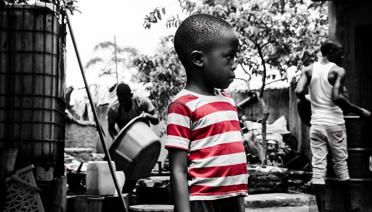 Kid standing on a poor street. Image to illustrate corruption. 