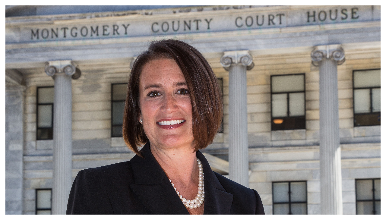 Judge Risa Vetri Ferman, a woman with short brown hair and a black blazer, stands before the Montgomery County Court House