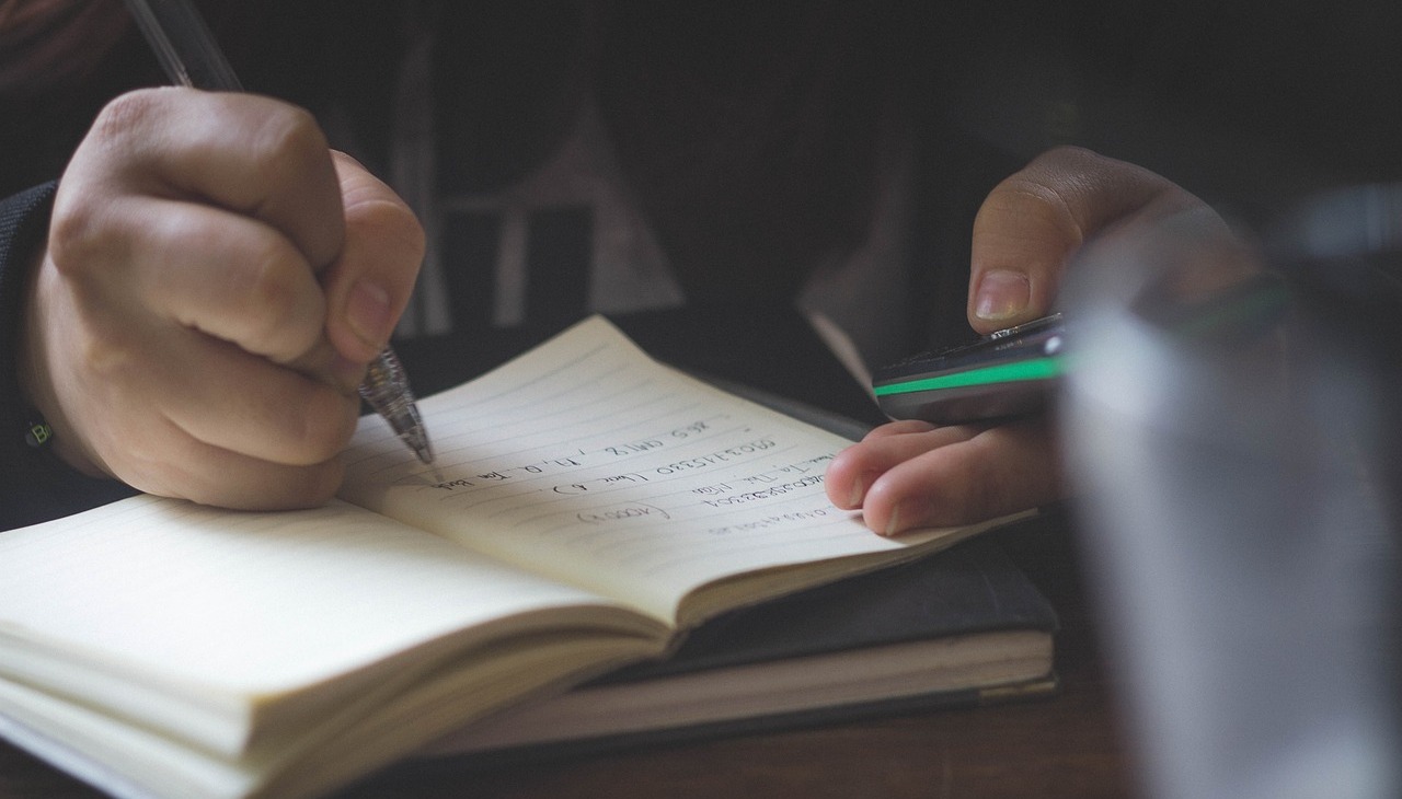 Person taking notes out of a cell phone.