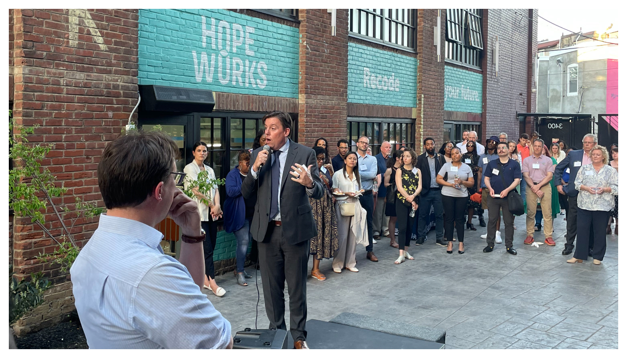 HopeWorks CEO Dan Rhoton listens to Bill Golderer speak before an audience in front of the HopeWorks building in Kensington.