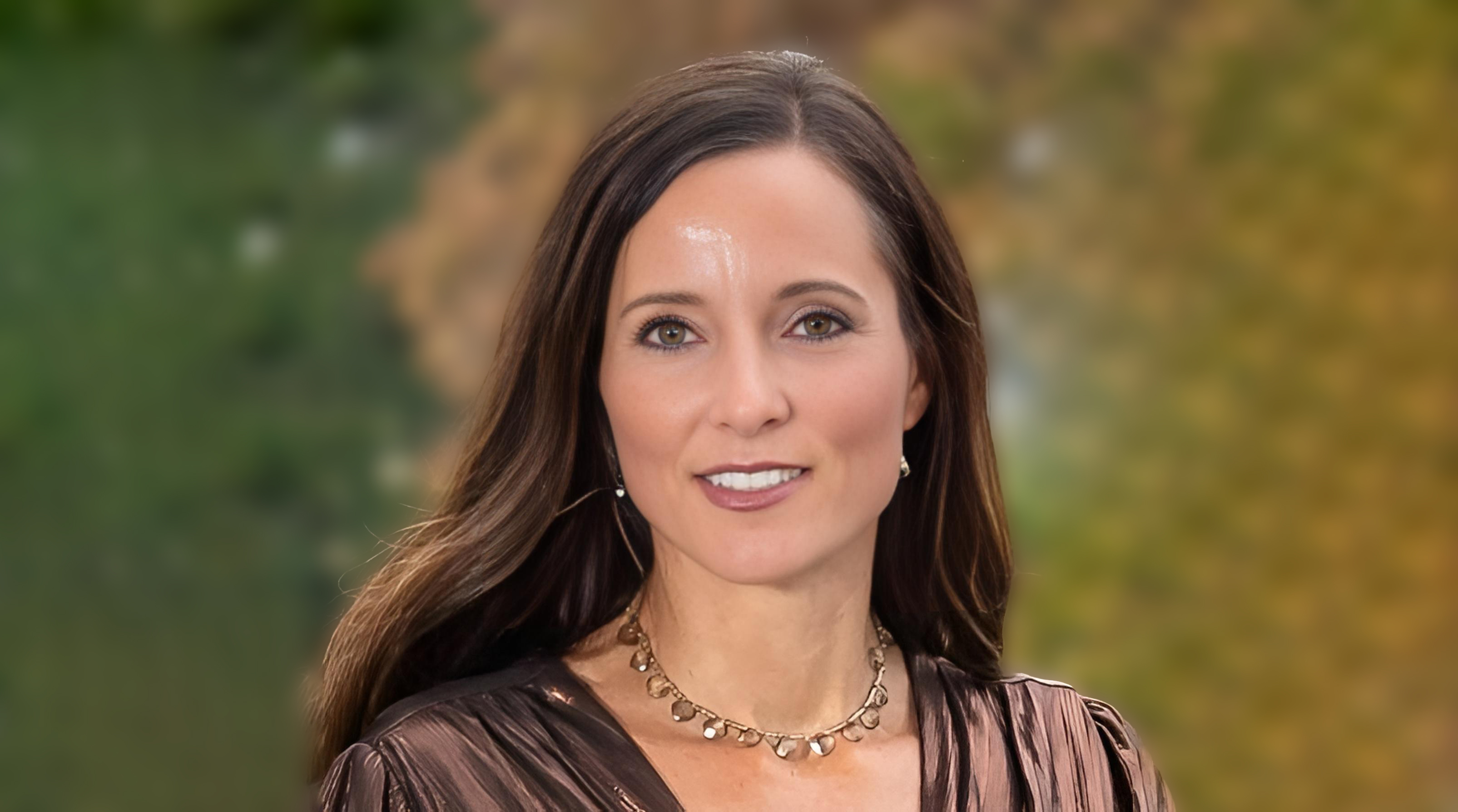 A headshot of Joanne Berrios, a woman with long brown hair and light skin.