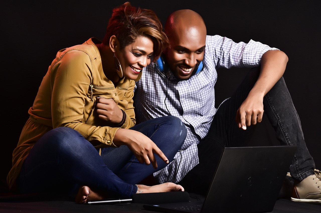 African American couple watching a video on a laptop. 