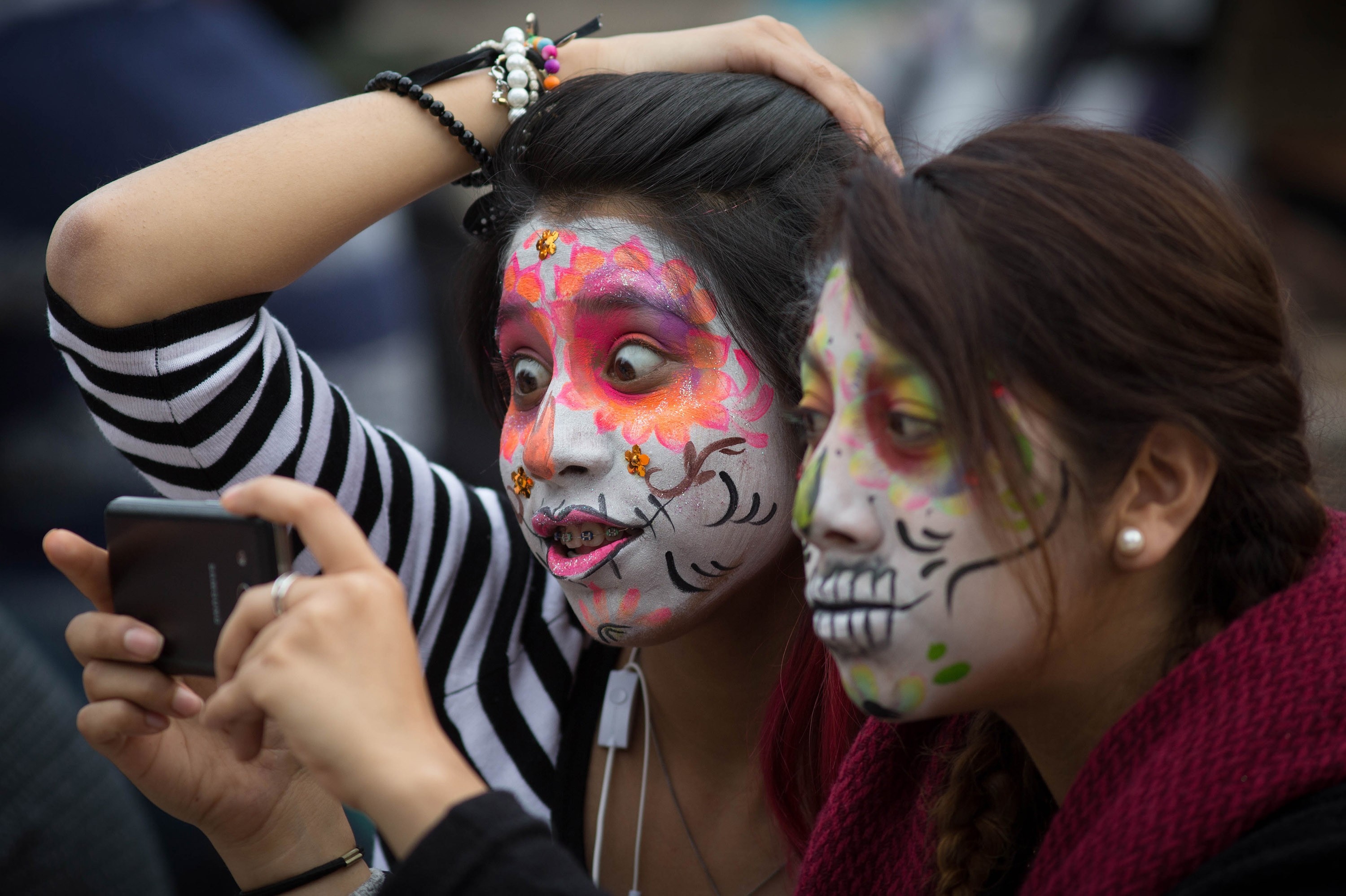  Two girls with make up take selfie during "Procession of the Catrinas" in Mexico City, Mexico