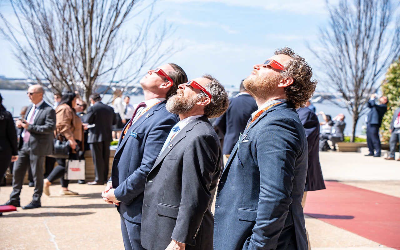 People at a convention in National Harbor, MD gaze into the sky in order to catch a glimpse of the solar eclipse. Photo: Peter Fitzpatrick/ALDIA News