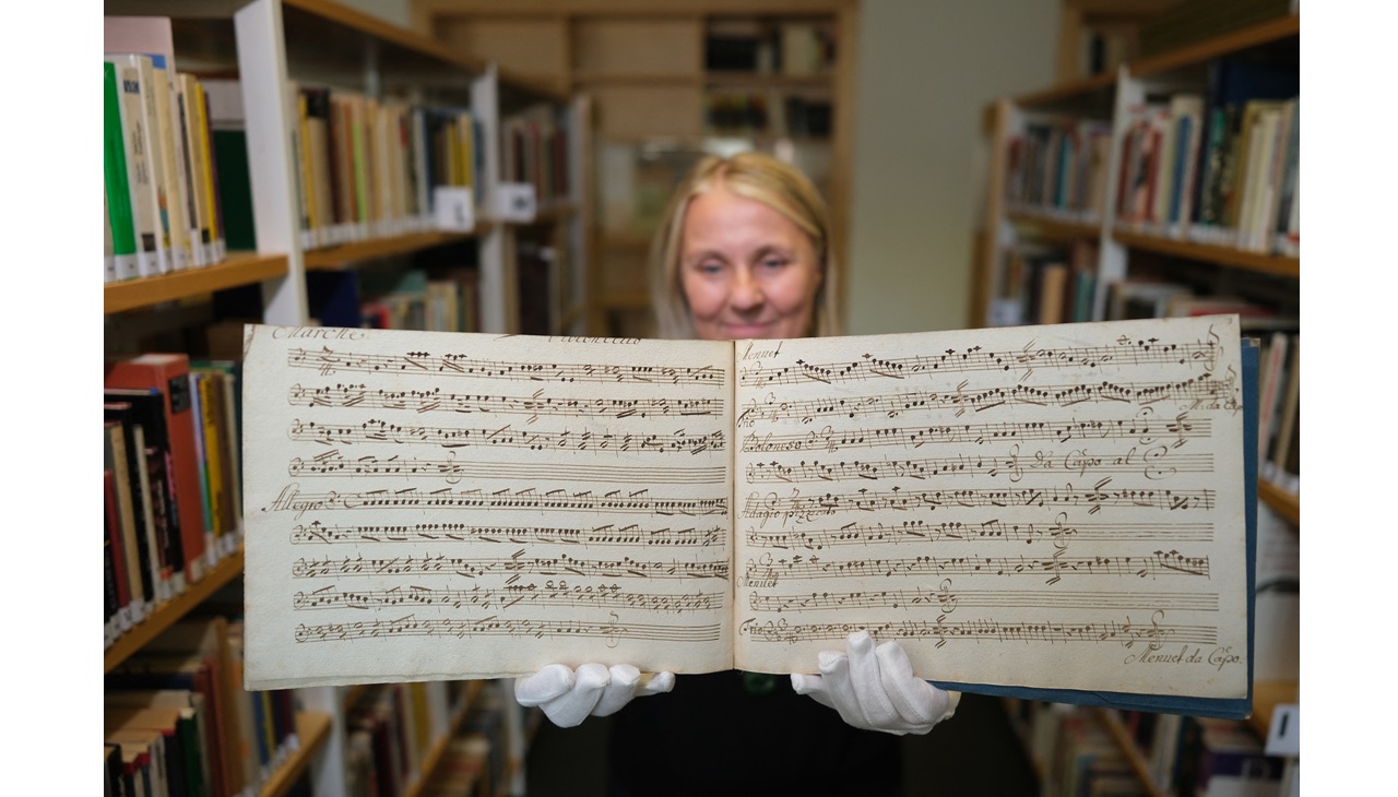 Korina Kilian, empleada de las Bibliotecas Municipales de Leipzig, sostiene en sus manos un manuscrito musical de Wolfgang Amadeus Mozart. La obra era desconocida hasta el momento. (Foto de SEBASTIAN WILLNOW / DPA / dpa Picture-Alliance vía AFP)