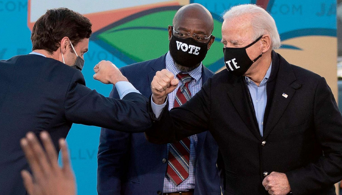 Senators-elect Jon Ossoff and Rev. Raphael Warnock of Georgia bump elbows with President-elect Joe Biden. Photo: Jim Watson/AFP via Getty Images