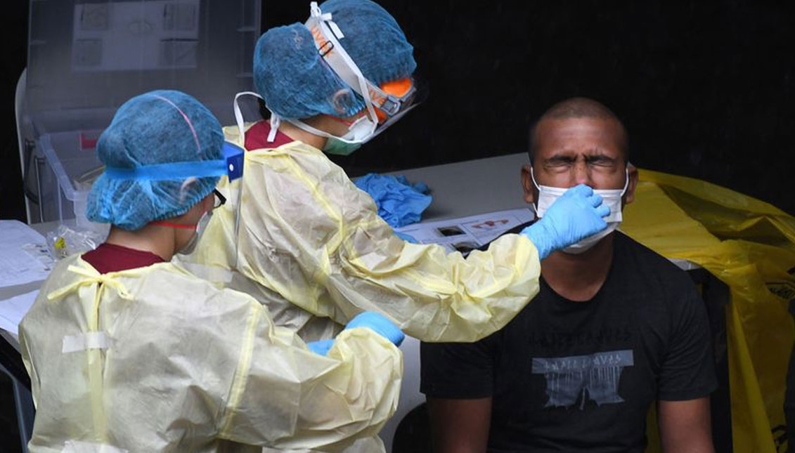 A healthcare worker collects a nasal swab sample from a migrant worker testing for the COVID-19 novel coronavirus at a dormitory in Singapore on April 27, 2020. Roslan Rahman—AFP/Getty Images