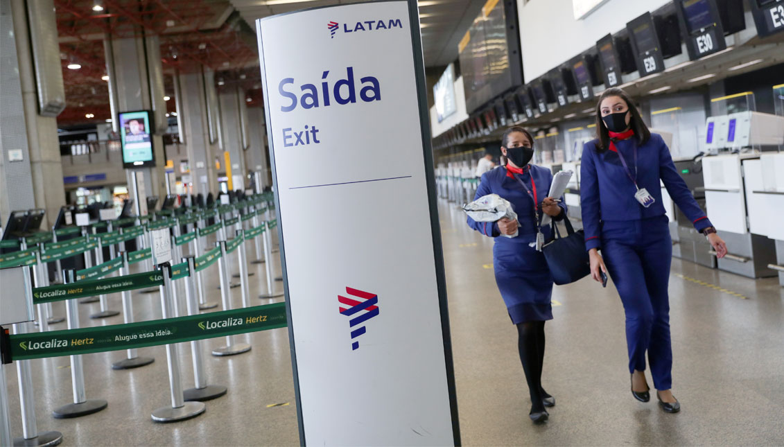 Latam Airlines employees walk at the company's check-in hall at Guarulhos International airport as air traffic is affected by the outbreak of the coronavirus disease (COVID-19), in Guarulhos, near Sao Paulo, Brazil, May 19, 2020.REUTERS/Amanda Perobelli/File Photo