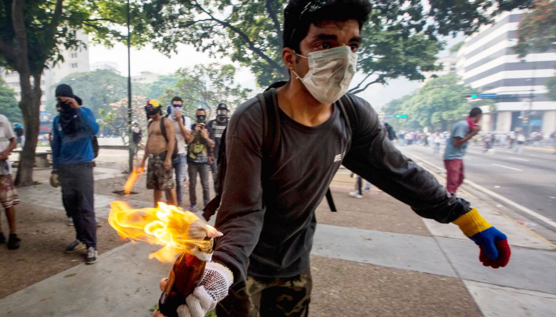 A demonstrator holds a Molotov cocktail during clashes with police during protests in Caracas, Venezuela, 19 April 2017. EPA/MIGUEL GUTIERREZ