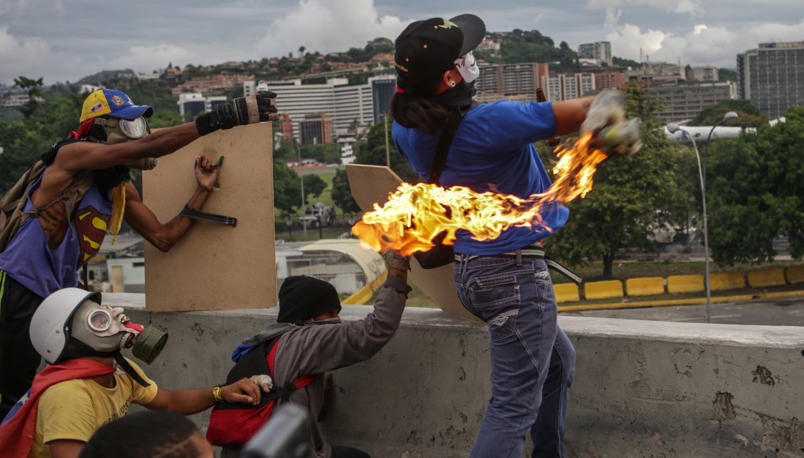 A masked demonstrator throws a Molotov cocktail during a protest organized by opponents of the Venezuelan government in Caracas, Venezuela, May 1, 2017. EPA/MIGUEL GUTIERREZ
