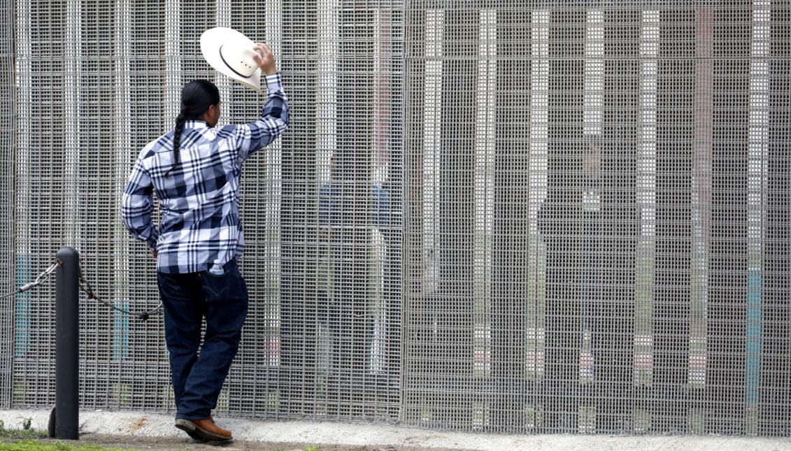 A man on the United States side talks to a relative on the Mexican side at the border fence between the United States and Mexico in the Border Field State Park in San Diego, California, USA, 26 March 2017. EPA/JASON SZENES
