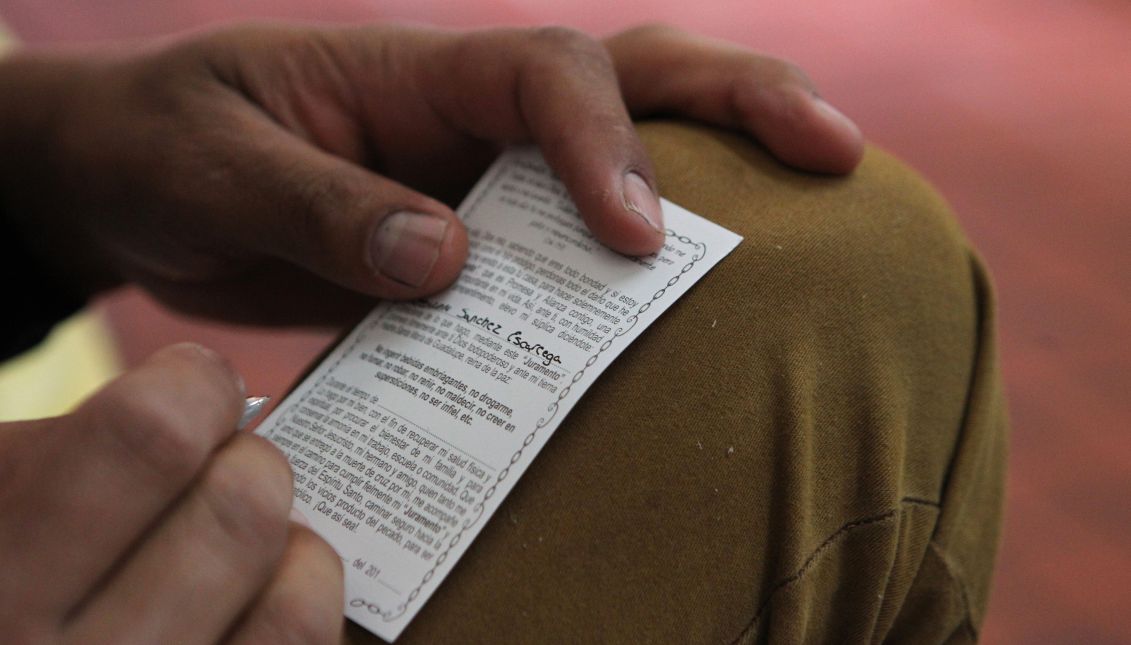 A man writing his promise to the Virgin of Guadalupe to break a personal dependency at the Basilica in Mexico City. EFE/Mario Guzman