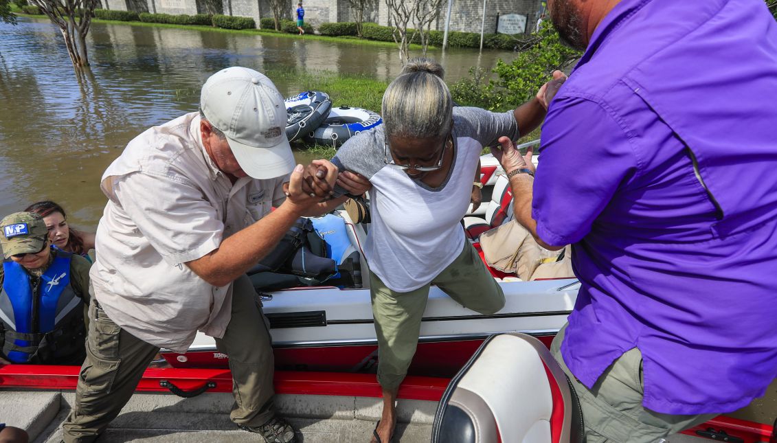 A flood victim (C) is helped into a boat by Danny Owens (L) and Brian Burden (R) as evacuations take place near Buffalo Bayou in the aftermath of Hurricane Harvey in Houston, Texas, USA, 30 August 2017. EPA-EFE/TANNEN MAURY
